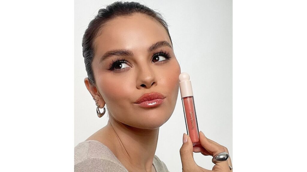 Selena Gomez holding a Rare Beauty Product.