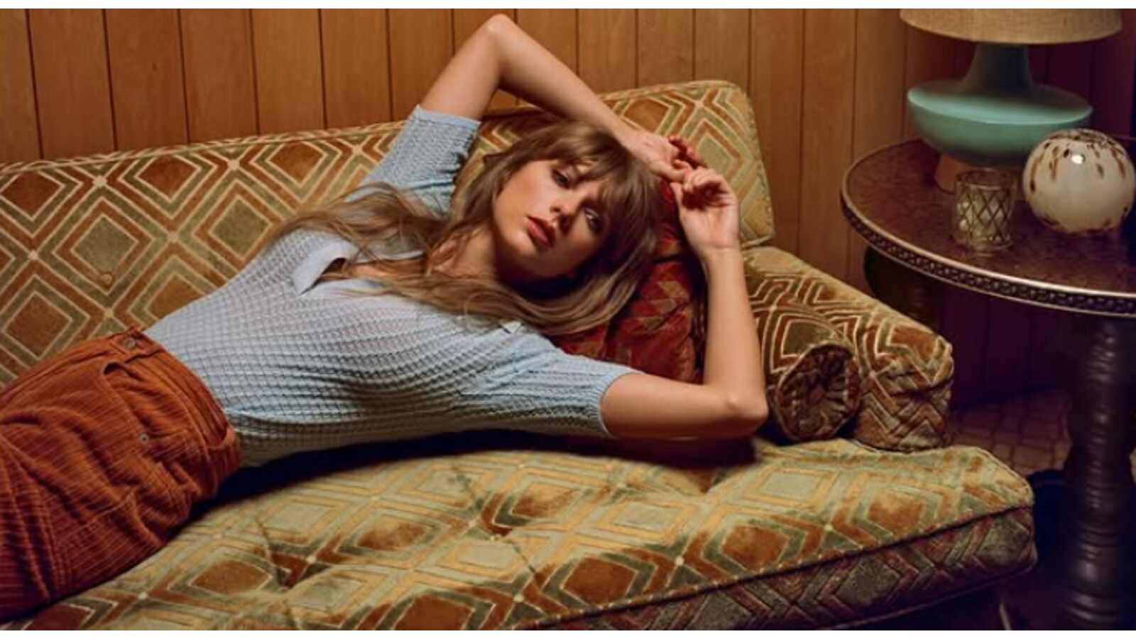 Taylor Swift laying on a couch.