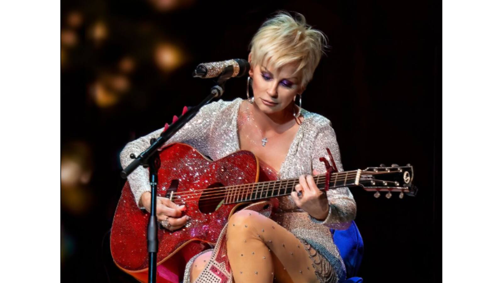 Lorrie Morgan playing a guitar.
